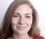 Close-up portrait of a smiling young woman with freckles and natural beauty.